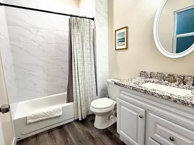 a bathroom with a toilet and a sink and a mirror at 5 Min Walk to UCD Med Ctr - Stylish New Build Home in Sacramento