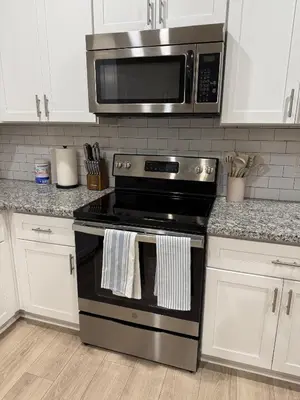 a kitchen with a stove and a microwave at 5 Min Walk to UCD Med Ctr - Stylish New Build Home in Sacramento