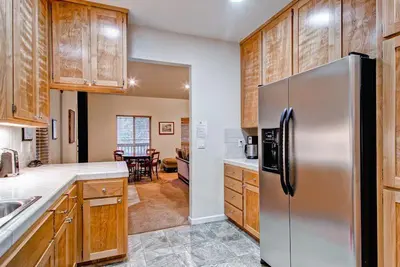 a kitchen with a stainless steel refrigerator and wooden cabinets at Eagles Nest in Yosemite West
