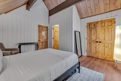a bedroom with a bed and a couch and wooden ceilings at Tahoe City Vacation Rental with Fireplace and Deck in Tahoe City