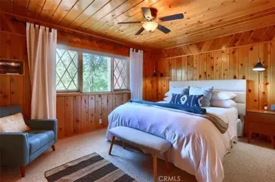 a bedroom with a bed and a ceiling fan at Lake View Cabin Private Dock Free Night Special in Bass Lake