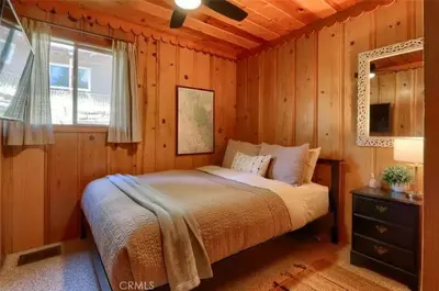 a bedroom with a bed in a wooden wall at Lake View Cabin Private Dock Free Night Special in Bass Lake