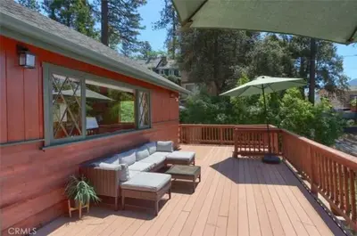 a patio with a couch and an umbrella on a deck at Lake View Cabin Private Dock Free Night Special in Bass Lake