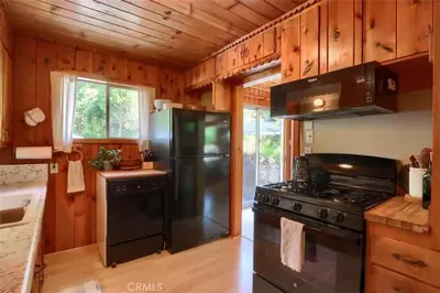 a kitchen with a black refrigerator and a stove at Lake View Cabin Private Dock Free Night Special in Bass Lake