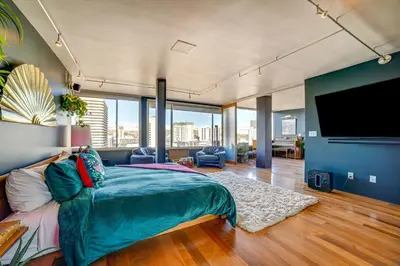 a bedroom with a large bed and a flat screen tv at Luxe Dtwn Reno Penthouse about 3 Mi to Casinos! in Reno