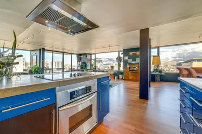a kitchen with blue cabinets and glass windows at Luxe Dtwn Reno Penthouse about 3 Mi to Casinos! in Reno