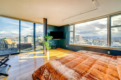 a bedroom with a large bed and large windows at Luxe Dtwn Reno Penthouse about 3 Mi to Casinos! in Reno