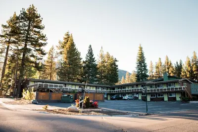 a large building with a parking lot and trees at Tea Garden Lodge in South Lake Tahoe