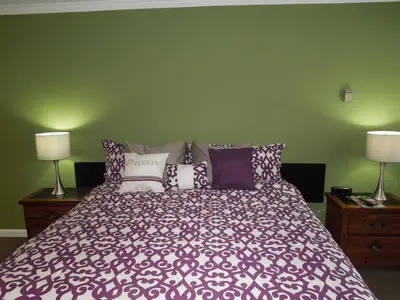 a bedroom with a large bed with purple and white pillows at Tea Garden Lodge in South Lake Tahoe