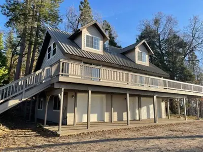 a large house with a large deck on top of it at Shaver Lake, 4 BDR HOT TUB Misty Mountain Retreat in Shaver Lake