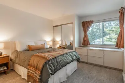 a bedroom with a large bed and a window at Crestview #3 bldg C 1 Bedroom plus Den / 2 Bathroom, close to town shuttle and short walk to village in Mammoth Lakes