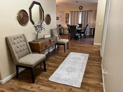 a living room with a mirror and chairs and a table at Cozy House in Fallon- 3BedRoom, 2BathRooms in Fallon