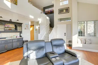 a living room with a leather couch and a staircase at Mtn-View Haven with Hot Tub! 28 Mi to Mt Rose Ski in Sparks