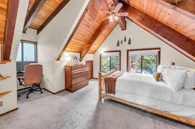 a bedroom with a bed and a desk and windows at Cozy Kings Beach Vacation Rental with Deck in Kings Beach
