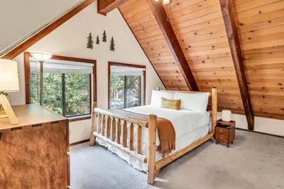 a bedroom with a bed in a room with wooden walls at Cozy Kings Beach Vacation Rental with Deck in Kings Beach