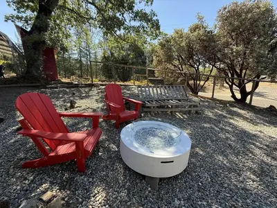two red chairs and a hot tub and a bench at The Firelight Lodge in Oakhurst