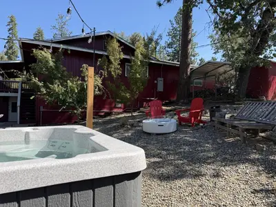 a hot tub in the yard of a house at The Firelight Lodge in Oakhurst