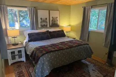 a bedroom with a bed with two lamps and two windows at Spacious Tahoe Hot Tub and Beach in Kings Beach