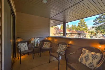 a porch with chairs and a table and a window at Lakeland Village 2 Bed Condo Pool View in South Lake Tahoe