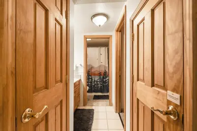 a hallway with wooden doors and a tile floor at Lakeland Village 2 Bed Condo Pool View in South Lake Tahoe