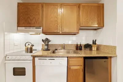 a kitchen with wooden cabinets and a sink at Lakeland Village 2 Bed Condo Pool View in South Lake Tahoe