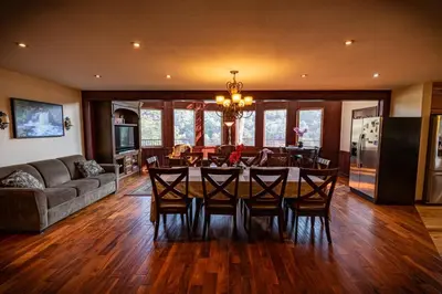 a dining room and living room with a table and chairs at Waterfall Lodge near Yosemite Endless Pool, Hot Tub, Playground in Oakhurst