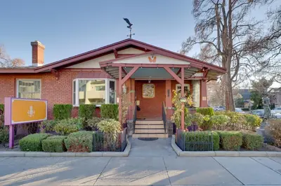 a red brick house with a sign in front of it at Steps to Truckee River Walk Rose Cottage in Reno