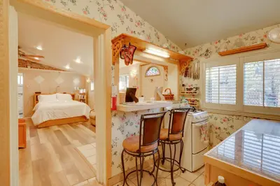 a kitchen with a bed and a kitchen with chairs at Close to Midtown! Cozy Reno River Cottage in Reno
