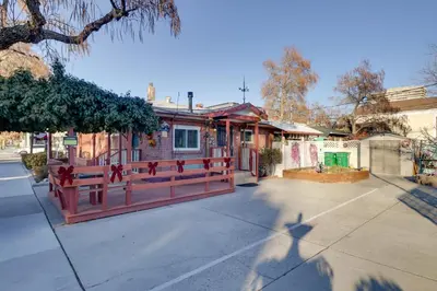 a house with a red fence in front of a street at Close to Midtown! Cozy Reno River Cottage in Reno
