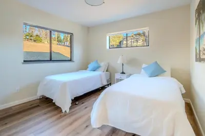 two beds in a room with two windows at Lakefront Villa with 180 degree view private dock and boats in Groveland