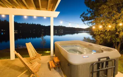a hot tub on a patio with a view of a lake at Lakefront Villa with 180 degree view private dock and boats in Groveland
