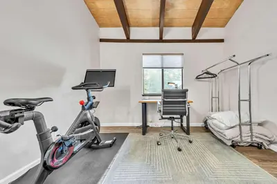 a room with a gym with a bike and a desk at Beautiful Homewood Retreat with Deck and Grill in Homewood