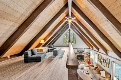 a living room with a vaulted ceiling with a large window at Beautiful Homewood Retreat with Deck and Grill in Homewood