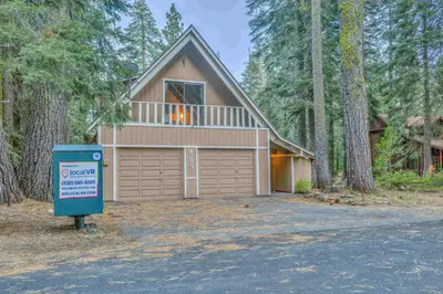 a house with a garage with a sign in front of it at Beautiful Homewood Retreat with Deck and Grill in Homewood