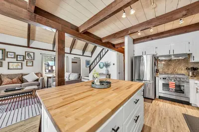 a kitchen and living room with wooden ceilings at Beautiful Homewood Retreat with Deck and Grill in Homewood