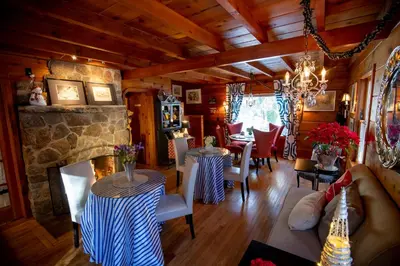 a living room with two tables and a fireplace at Elliott House Boutique Inn in Shaver Lake