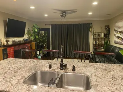 a kitchen with a sink and a living room at English Rose Garden Cottage near Roseville, CA in Citrus Heights