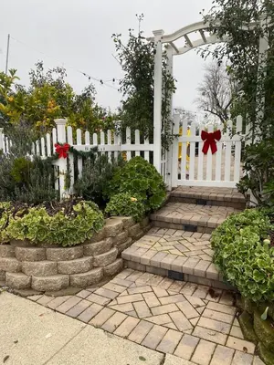 a white fence with a gate and some plants at English Rose Garden Cottage near Roseville, CA in Citrus Heights