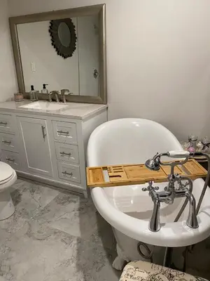 a bathroom with a tub and a sink and a mirror at English Rose Garden Cottage near Roseville, CA in Citrus Heights