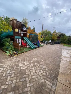 a playground with a slide in front of a building at English Rose Garden Cottage near Roseville, CA in Citrus Heights