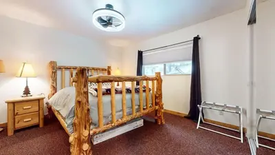 a bedroom with a wooden bed and a window at Meridian Villas #10 condo in Mammoth Lakes