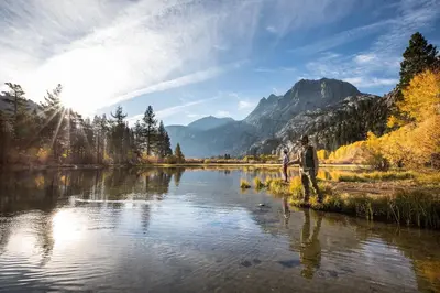 a man is standing on the shore of a river at Meridian Villas #10 condo in Mammoth Lakes
