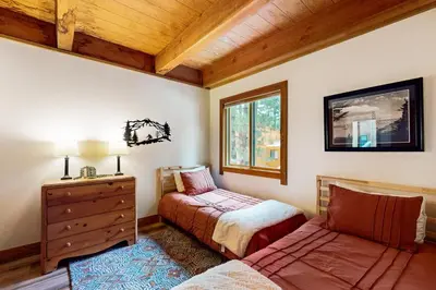 a bedroom with two beds and a dresser and a window at Northstar Retreat in Kingswood Estates