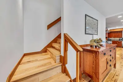 a staircase in a home with white walls and wooden floors at Stunning Mountain Gem with Hot Tub Near Palisades in Olympic Valley