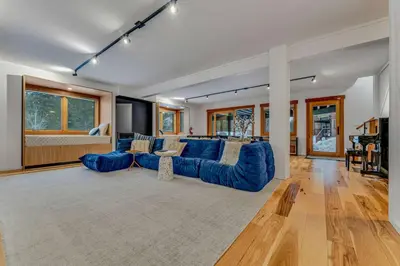 a large living room with a blue couch and a table at Stunning Mountain Gem with Hot Tub Near Palisades in Olympic Valley