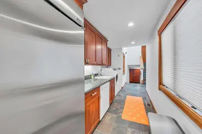 a kitchen with wooden cabinets and an orange rug at Stunning Mountain Gem with Hot Tub Near Palisades in Olympic Valley