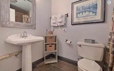 a bathroom with a sink and a toilet and a mirror at Ski Den - Steps to Mammoth Village! in Mammoth Lakes