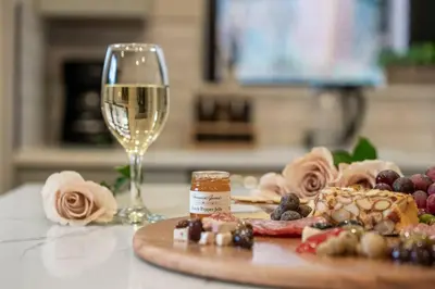 a table with a glass of wine and a plate of food at Luxury Living Modern Midtown Ensuite Baths Patio in Reno