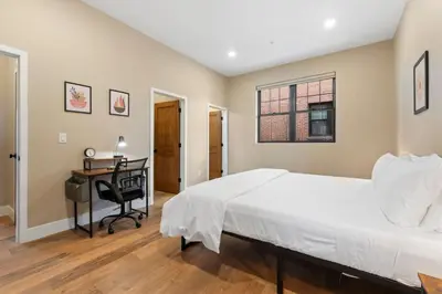a bedroom with a bed and a desk and a window at Luxury Living Modern Midtown Ensuite Baths Patio in Reno