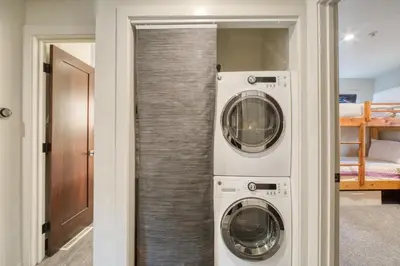 two washing machines in a room with a closet at Valley View Townhome # 10 at Palisades by Tahoe Getaways - Shuttle & Walk to the Village! in Olympic Valley